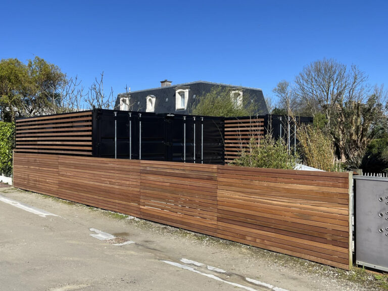 Garage en container dans la Manche avec finition en bois et peinture noir graphite RAL 9011.