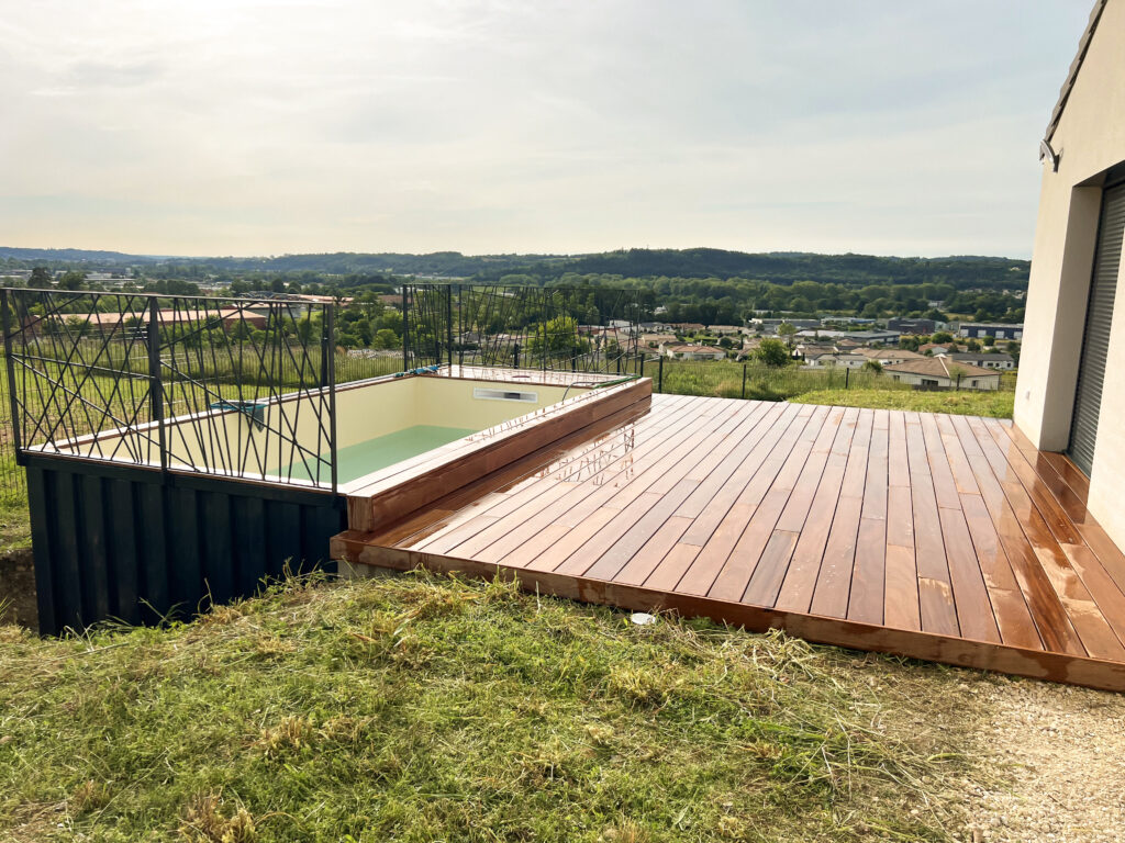 Piscine container d'In'Box Aménagement entourée d'une terrasse en bois Cumaru, offrant une vue étendue sur le paysage.