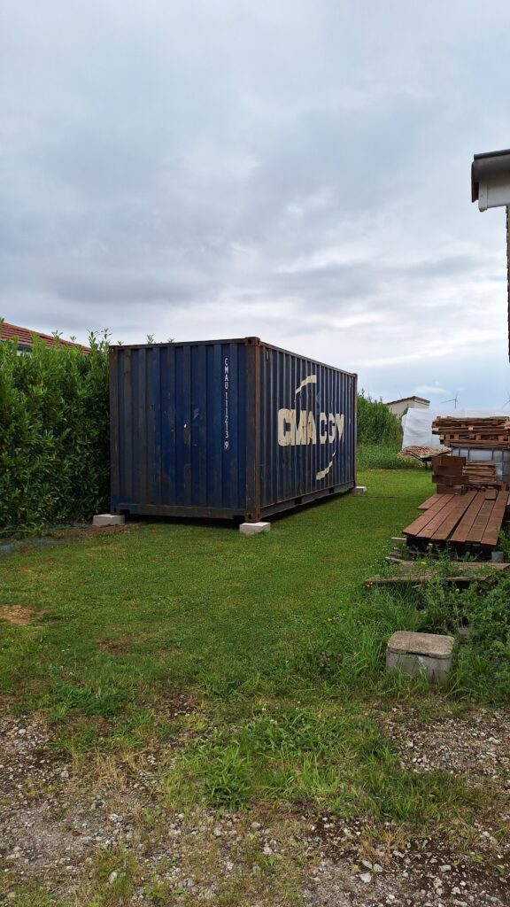 Container maritime de 20 pieds installé dans un jardin à Aulnois-sur-Seille pour le stockage de matériel de jardin et de bois.