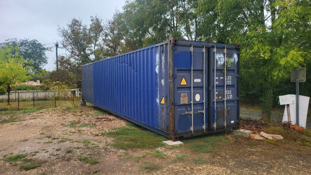 Container maritime de 40 pieds installé dans un jardin à Saint-Barthélemy-de-Bellegarde pour le stockage d'équipements et un atelier de peinture.